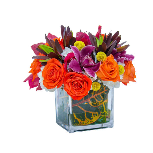 Bright bouquet of orange roses and purple flowers in a glass vase