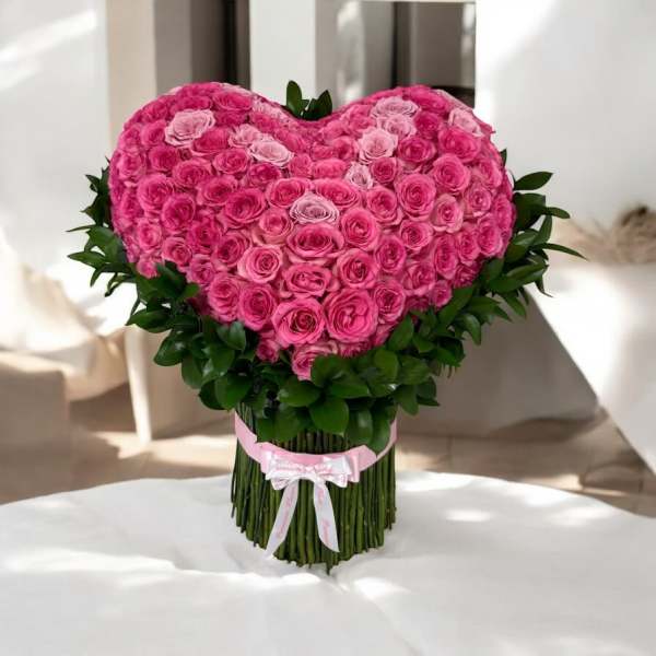 Heart-shaped bouquet of pink roses with a ribbon wrap