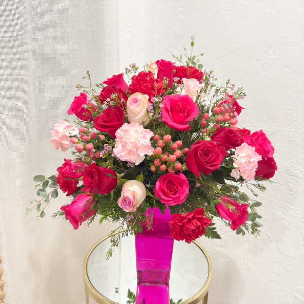 Pink and red rose bouquet in a bright pink vase