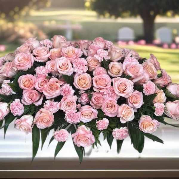 Pink rose and carnation casket spray with dark greenery