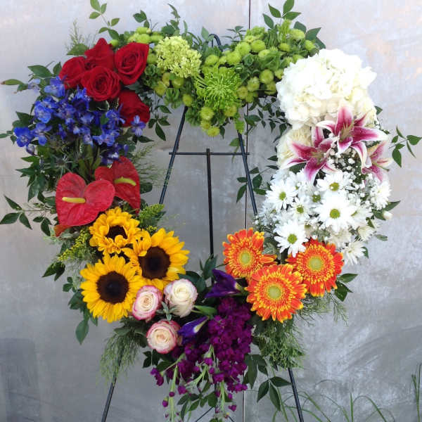 Heart-shaped floral wreath on an easel with mixed bright flowers