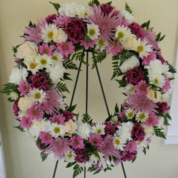 Pink and white floral wreath on a black easel
