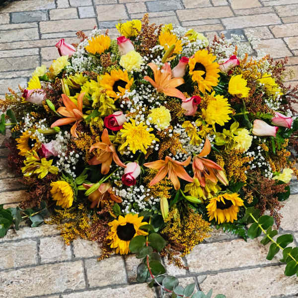 Large floral spray with sunflowers, roses, lilies, and yellow blooms