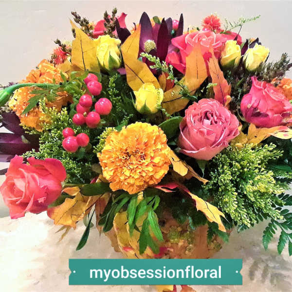 Colorful bouquet of roses and marigolds with autumn leaves