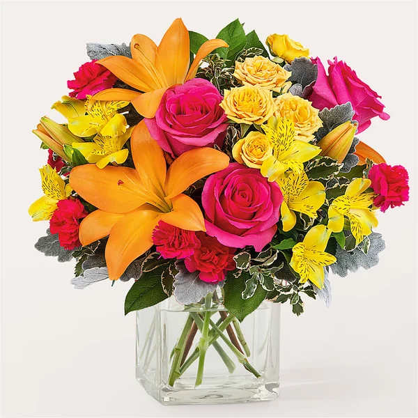 Bright bouquet of pink roses, yellow flowers, and orange lilies in a clear vase