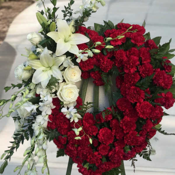 Red and white floral funeral wreath on an easel