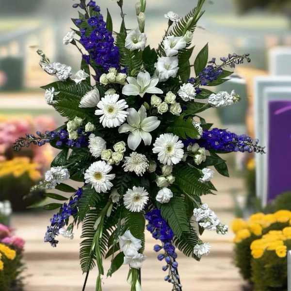 Standing floral spray with white and purple flowers on a metal easel