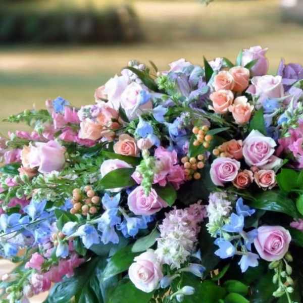 Large pastel floral arrangement with pink roses and blue flowers