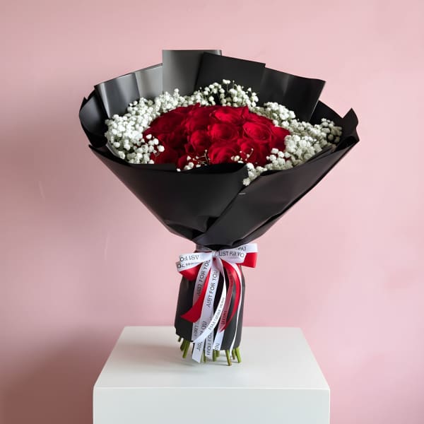 Bouquet of red roses with white baby's breath in black wrap