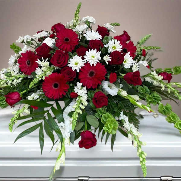 Red and white floral casket spray with roses and daisies