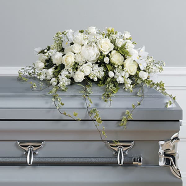 White floral spray on a silver casket