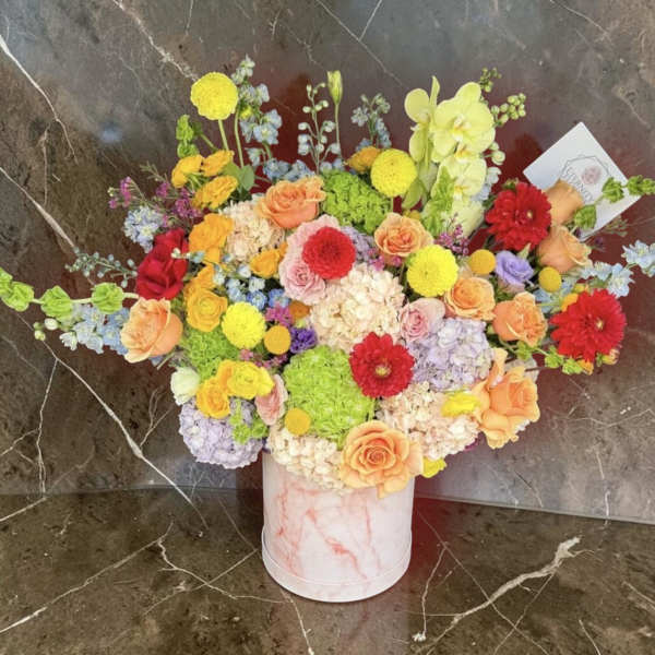Colorful mixed bouquet in a pink marble-look cylinder vase