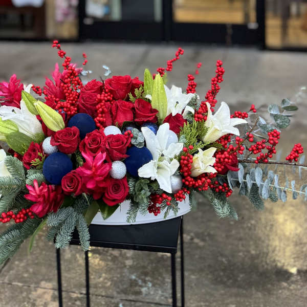 Long floral arrangement with red and white flowers in a low container