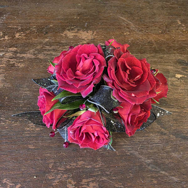 Small bouquet of bright pink roses with black ribbon accents