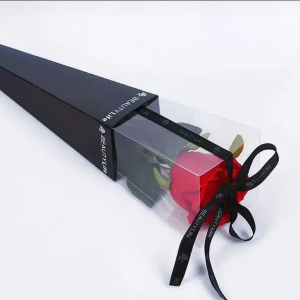 Single red rose in a clear gift box with a black ribbon bow