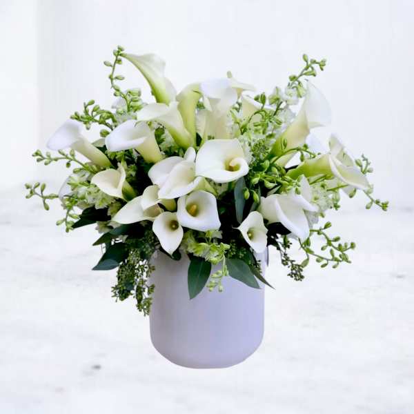 White calla lily bouquet in a pale vase