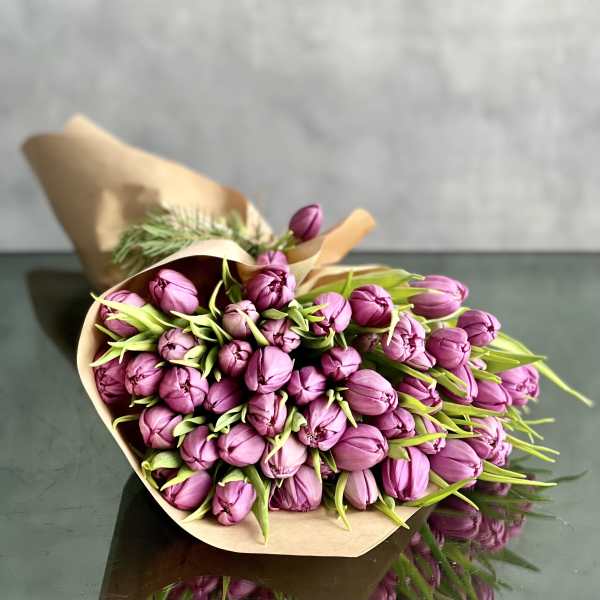 Bouquet of purple tulips wrapped in brown paper