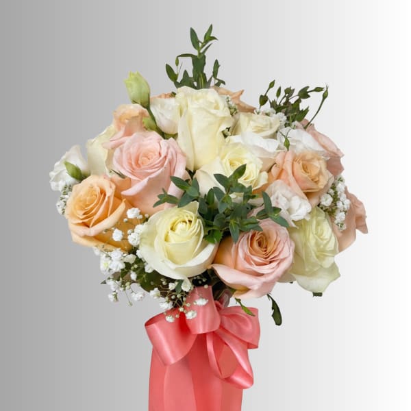 Bouquet of pastel roses with baby’s breath and a pink ribbon