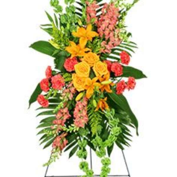 Standing floral spray with yellow roses and pink flowers on a metal easel