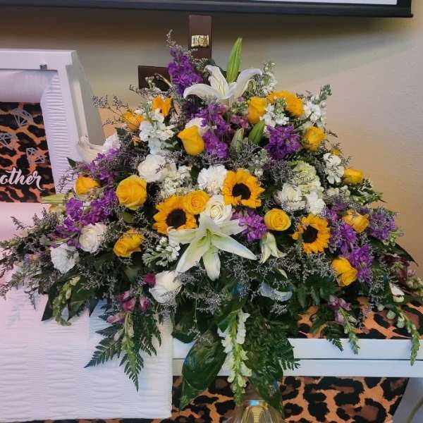 Large mixed floral arrangement with lilies, roses, and sunflowers