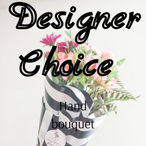 Hand bouquet of pink and white flowers wrapped in black-and-white paper