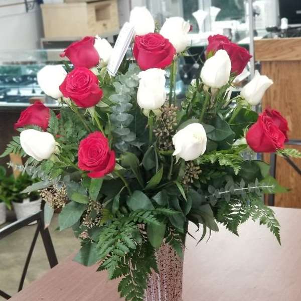 Red and white roses arranged in a silver vase
