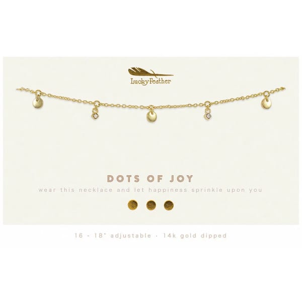 Gold charm necklace with small discs and crystal accents on a branded display card