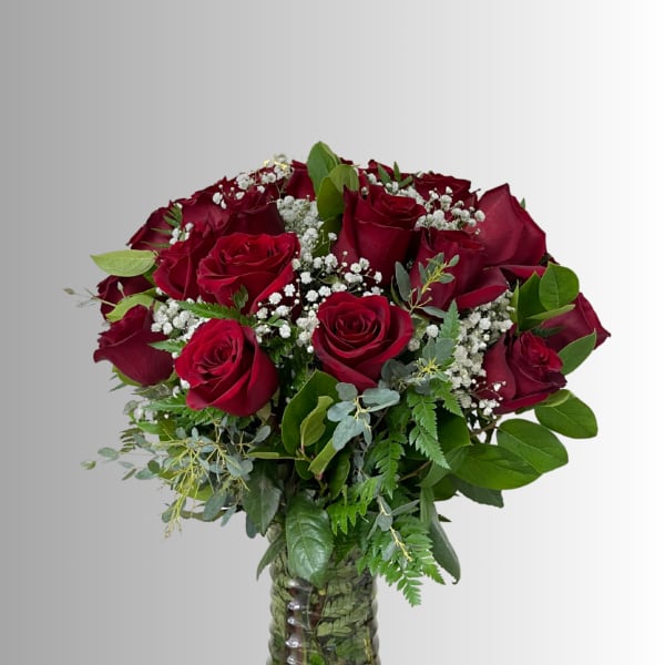 Bouquet of red roses with baby's breath in a glass vase