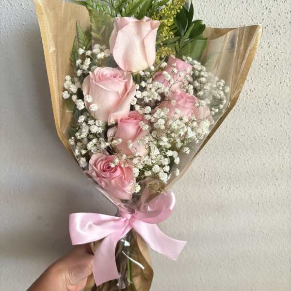 Bouquet of pink roses with baby's breath and a pink ribbon