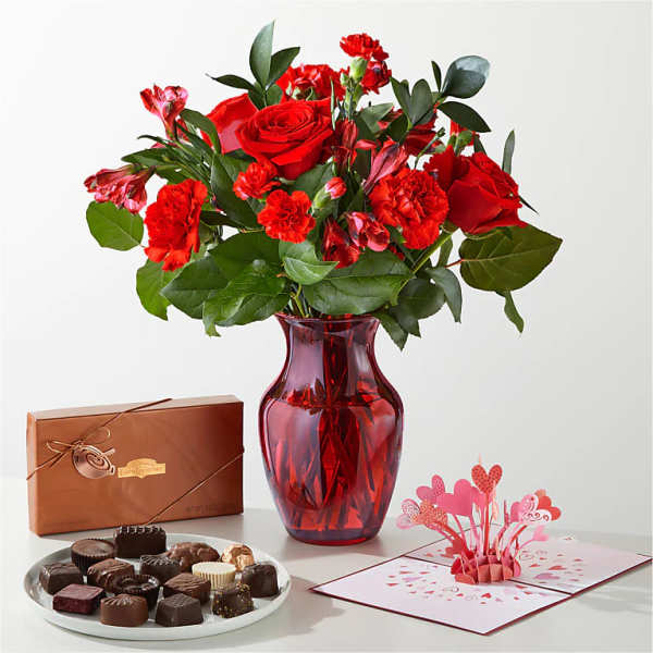 Red rose bouquet in a red vase with chocolates and a pop-up card