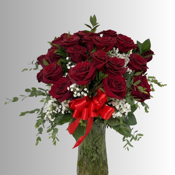 Bouquet of red roses in a glass vase with a red ribbon