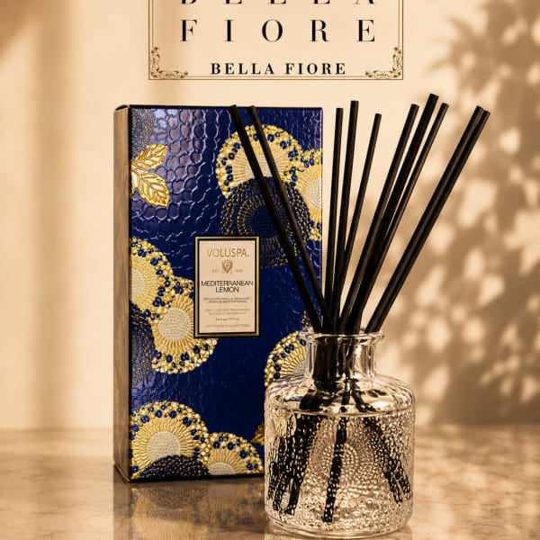 Reed diffuser in a clear glass bottle with a decorative blue box