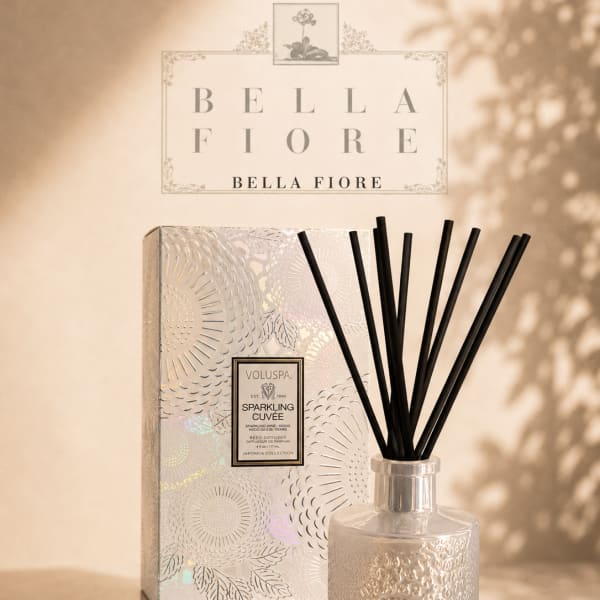 A reed diffuser in a patterned glass bottle with a matching box