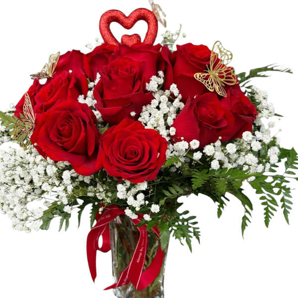 Red roses in a glass vase with baby's breath and butterfly accents