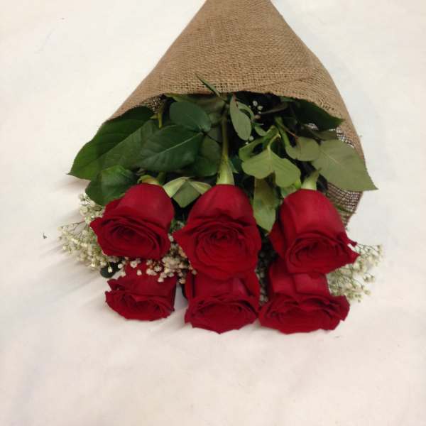 Bouquet of red roses wrapped in burlap with baby's breath