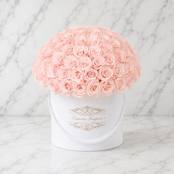 Round bouquet of pale pink roses in a white hat box