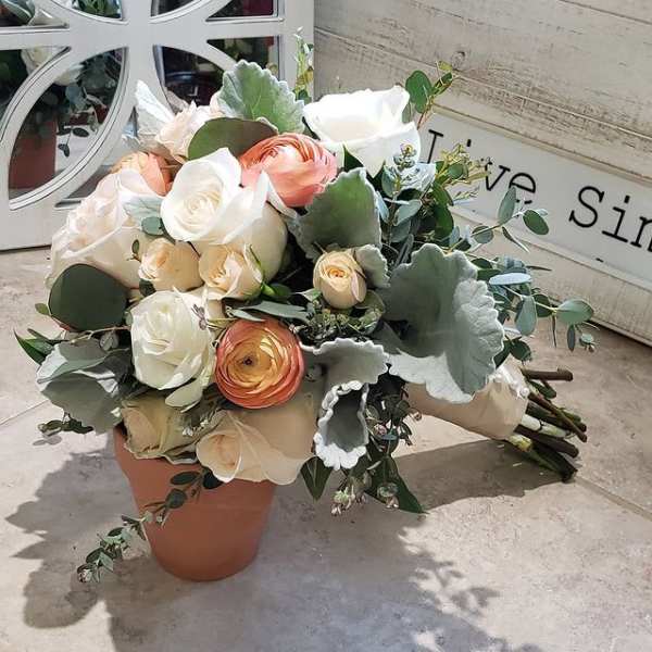 Bouquet of white and peach roses with eucalyptus in a terracotta pot
