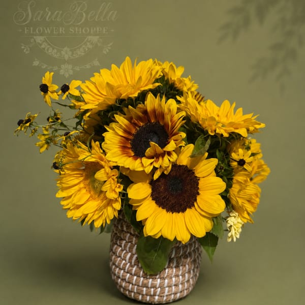 Yellow sunflower bouquet in a woven basket vase
