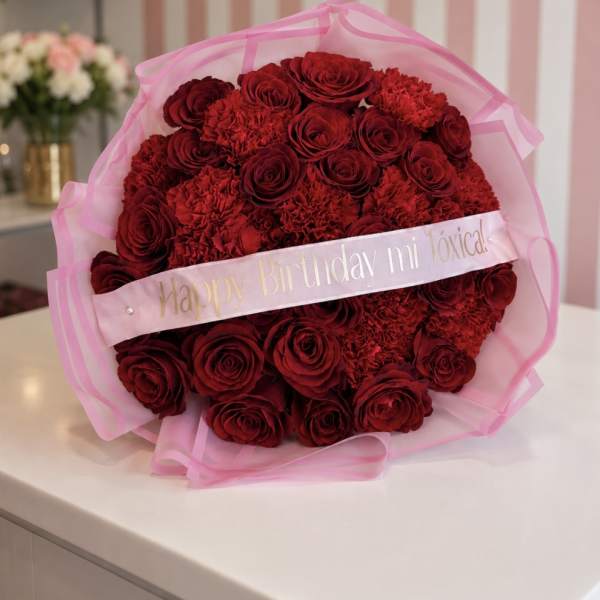 Bouquet of red roses and carnations wrapped in pink tulle