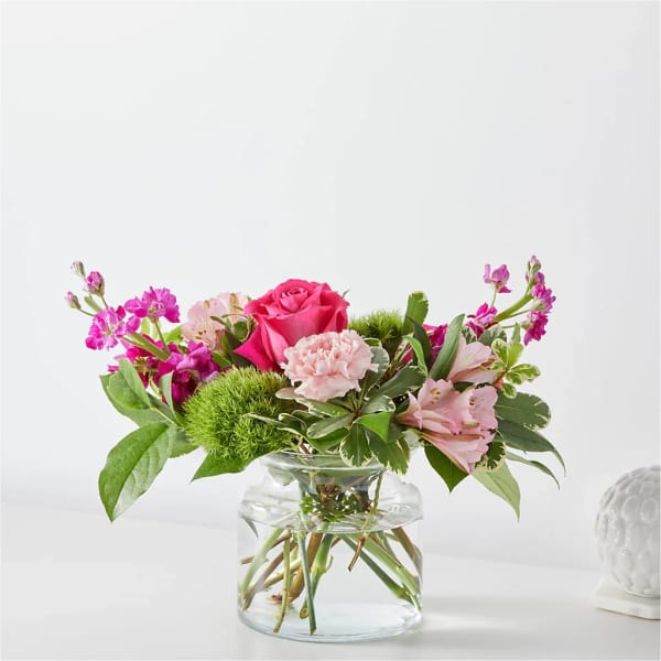Pink rose and carnations in a clear glass vase