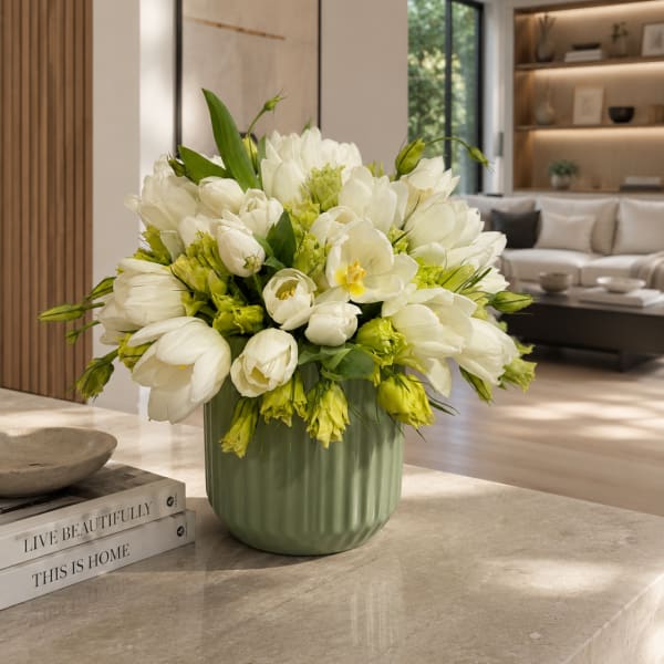White tulips and green blooms arranged in a green vase