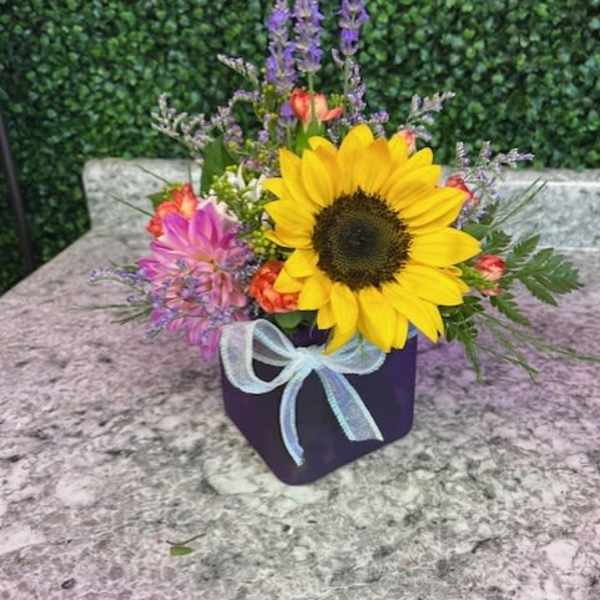 Sunflower arrangement in a purple box with a light blue ribbon
