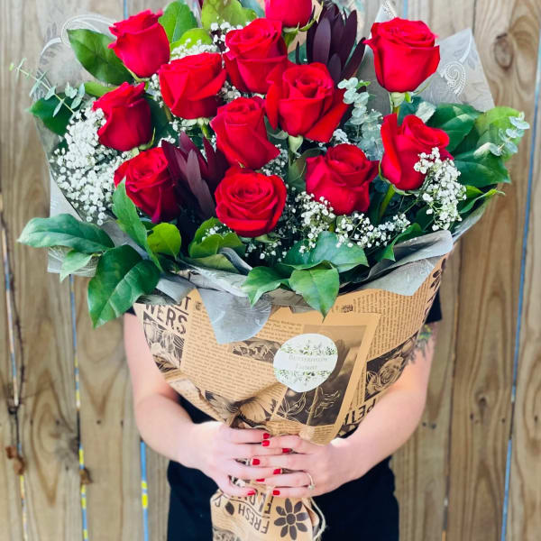 Large bouquet of red roses wrapped in brown paper