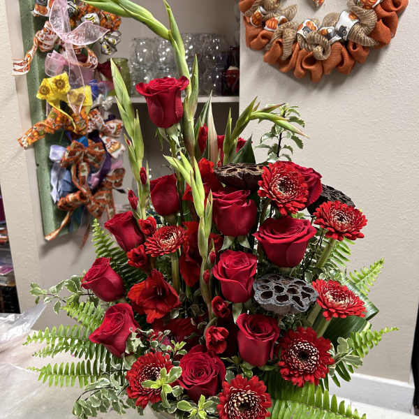 Tall arrangement of red roses and red chrysanthemums in a vase