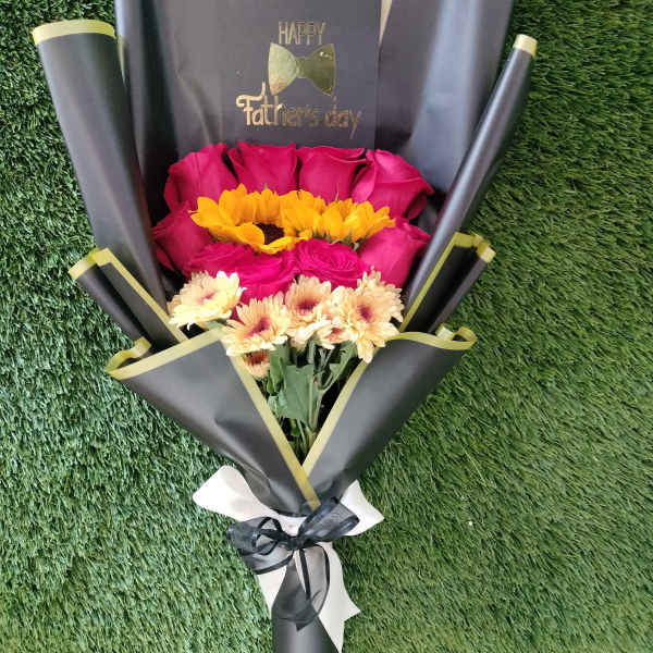 Bouquet of pink roses and yellow daisies wrapped in black paper
