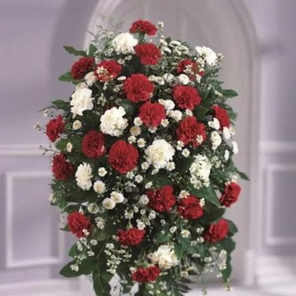 Standing spray of red and white carnations with white daisies on a metal easel