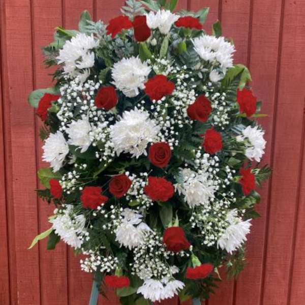 Tall red and white standing spray with roses, carnations, and mums on a metal easel