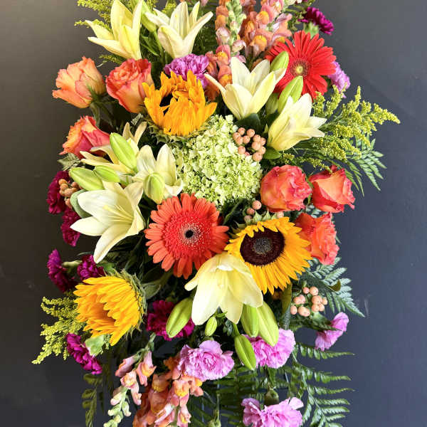 Tall mixed flower spray with lilies, gerberas, roses, and snapdragons