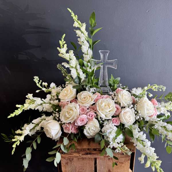 White and pink rose arrangement with a clear cross centerpiece
