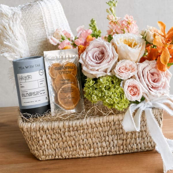 Flower gift basket with roses, hydrangeas, tea, and dried orange slices